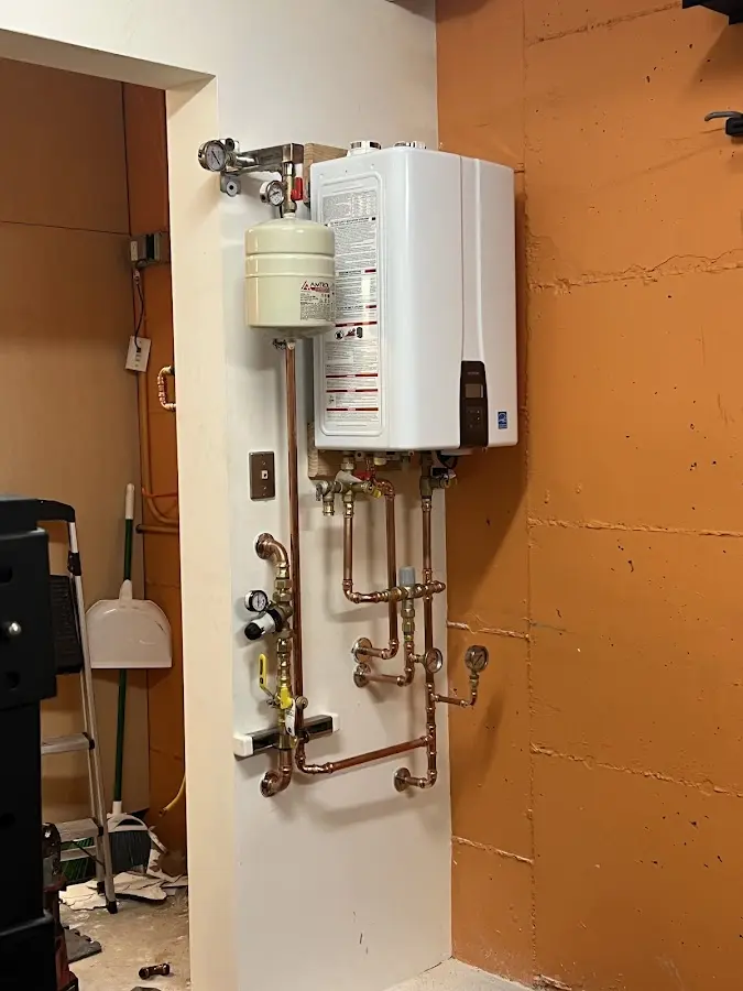 Plumbing technician inspecting water heater connections in Villa Hills